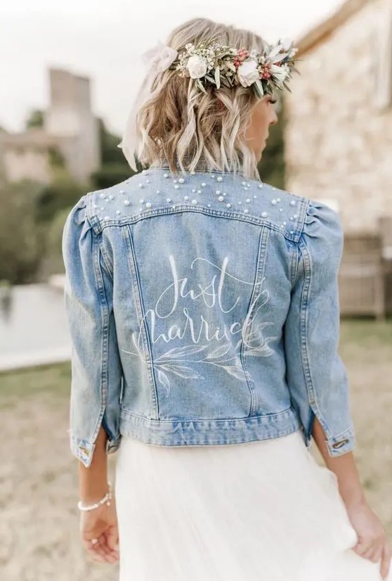 a delicate blue denim cropped bridal jacket with short sleeves, a bit of calligraphy and pearls over the shoulders is chic