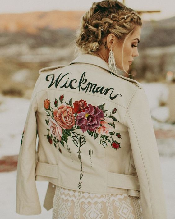 a white leather jacket with bright hand painted blooms and greenery, black patterns and a new second namde for a boho bride