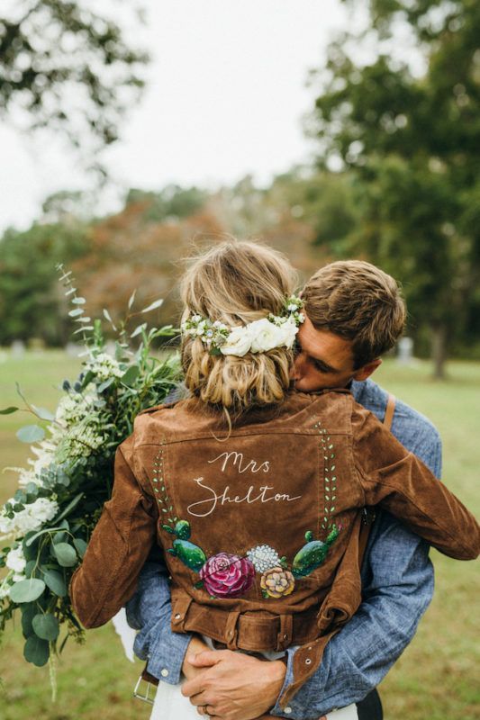 a brown suede jacket with bright painted blooms and cacti plus leaves for a rustic and boho bride