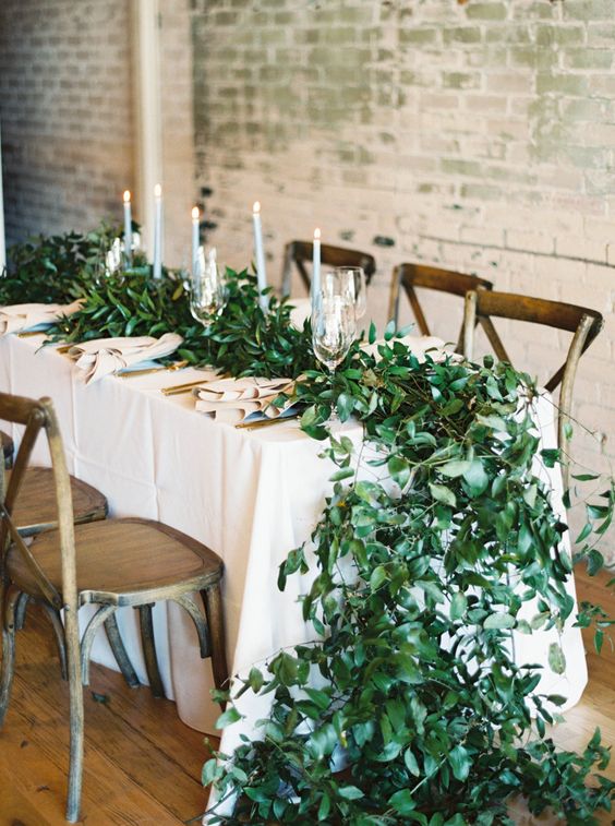 a super lush greenery table garland is a chic and stylish idea for a spring wedding, it looks really spectacular