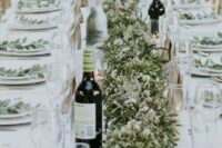 15 a textural greenery wedding table garland dotted with some white blooms and candles is a stylish idea for a spring or summer wedding