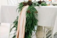21 an exquisite winter table runner of evergreens, pinecones and blush ribbons will fit even the most refined winter wedding and will give it a cozy feel