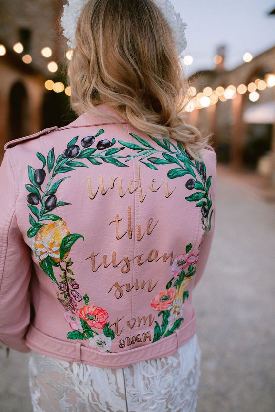 a pink leather jacket with hand painted blooms and olive branches and gold calligraphy for a Tuscany wedding