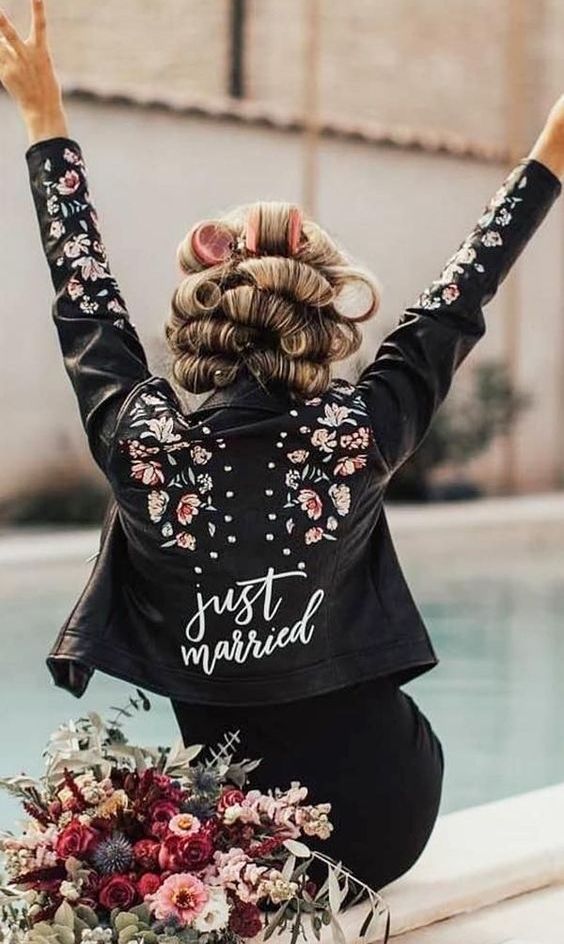 a black leather jacket with hand painted blooms, studs and white calligraphy is a bold and catchy cover up to rock