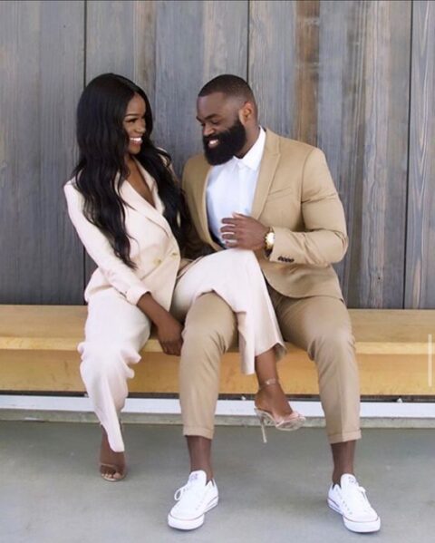 a tan suit, a white shirt and white sneakers for a stylish wedding guest look and to match the couple’s look