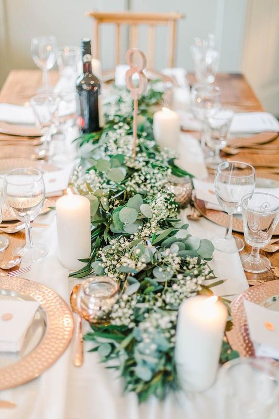 a beautiful and delicate greenery table runner with baby's breath is a lovely idea for a modern wedding, dot it with pillar candles