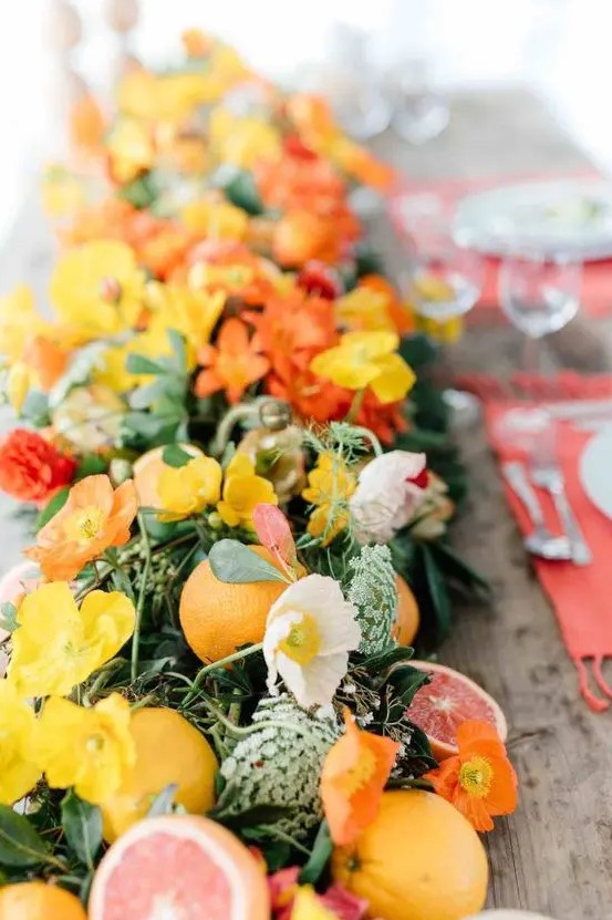 a bright greenery table runner with citrus, white and yellow flowers for a bold look on the tropical wedding table