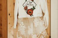 30 a white leather jacket with bold painted blooms and a frame is a catchy and bold idea for a modern bride