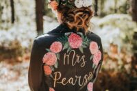 31 a black leather jacket with painted pink blooms and greenery, with gold calligraphy and a matching floral crown for a woodland bride