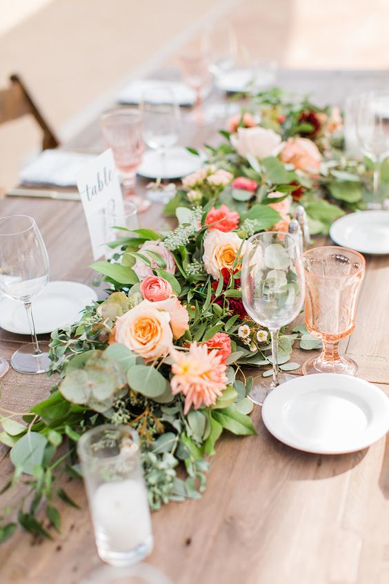 a greenery and bright pink and coral bloom table runner is a perfect solution for a bright spring or summer wedding