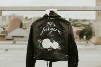 33 a black leather jacket with painted white blooms, white calligraphy and fringe on the sleeves is a stylish idea