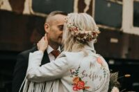 34 a white cropped leather jacket with long fringe on the sleeves, painted blooms and calligraphy is a cool idea for a boho bride