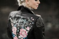 35 a black leather jacket with studded shoulders and a collar, with a floral paint back and calligraphy is a stylish idea for a bold look