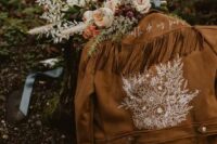 38 a brown suede jacket with hand painted white blooms, calligraphy and long fringe on the back is ideal for a boho bride