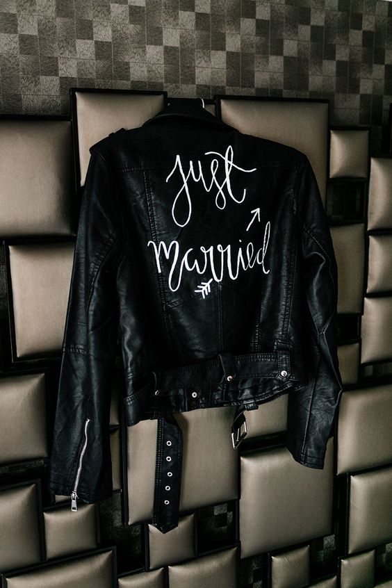 a black leather jacket with white calligraphy painted is a lovely cover up for a bride who wants a bit of edge