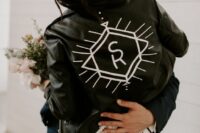 42 a black leather jacket with white painting and monograms is a stylish idea for a boho bride, it looks laconic and stylish