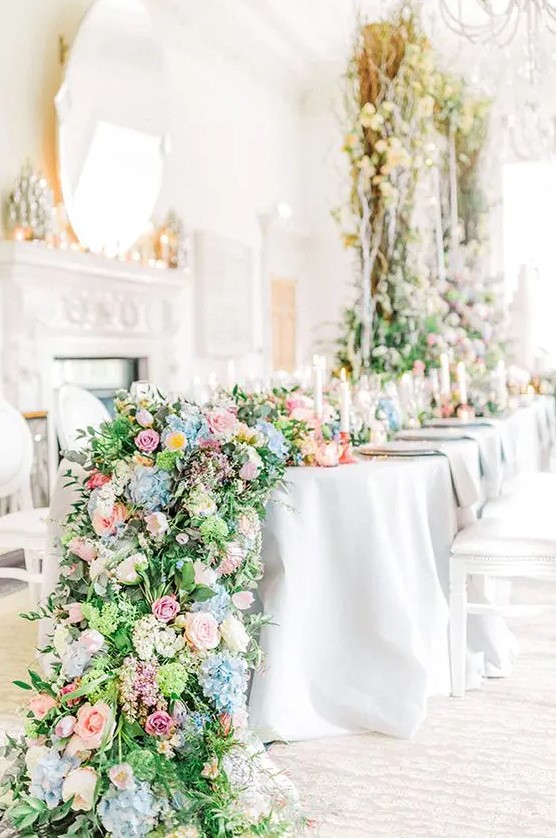 a super lush oversized greenery and blooms table runner in blue, mauve, pink, dusty pink looks like a whole carpet of flowers
