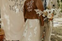 43 a brown leather jacket wiht white calligraphy painted is a cool and lovely cover up to rock at a boho wedding