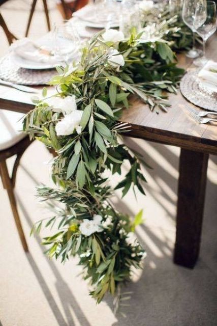 a textural greenery wedding table garland with white blooms is a beautiful and cool idea for a modern spring or summer wedding