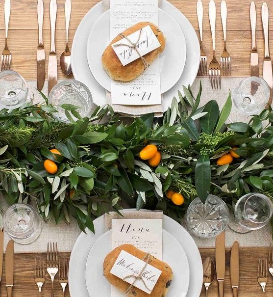 a bold and cool textural greenery table runner dotted with citrus is a cool idea for a modern tropical or just summer wedding