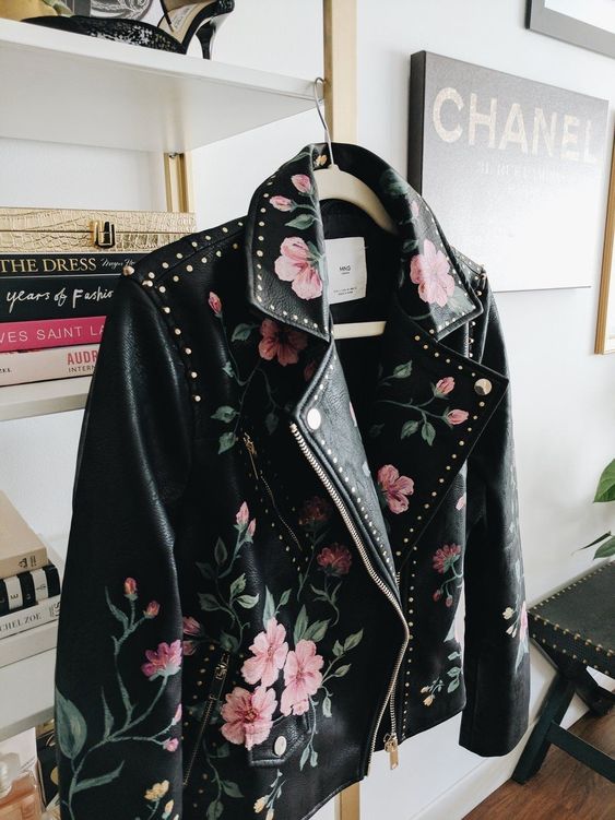 a gorgeous black leather jacket with hand painted blooms and studs all over the jacket, not just on the back