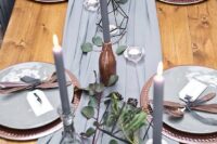 50 a grey fabric table runner, grey candles, tealights in terrariums and eucalyptus for a refined tablescape