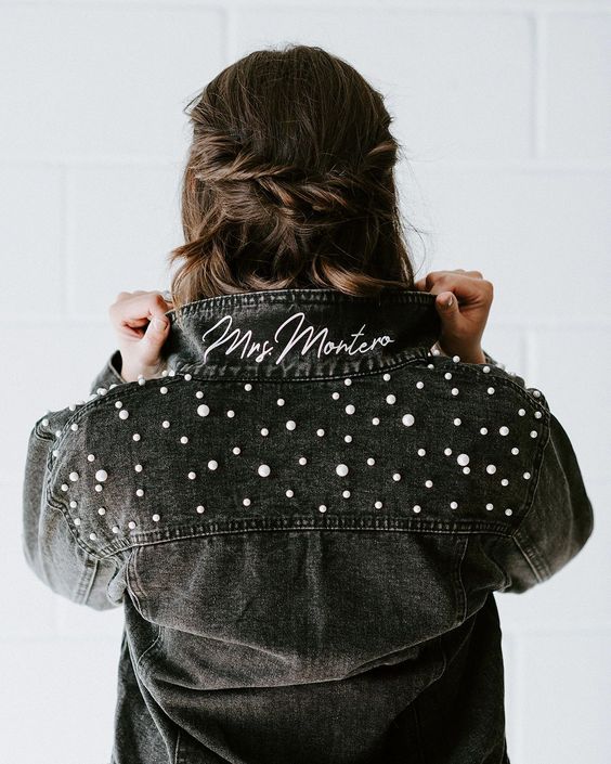 a black denim bridal jacket with white calligraphy and pearls over the shoulders is a stylish and cool idea to try