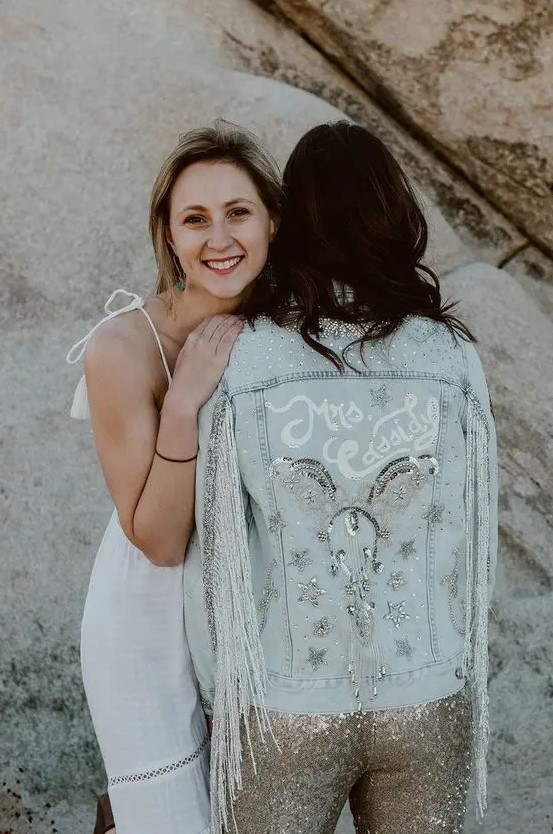 a bleached denim jacket with silver fringe, white calligraphy, crystals, embellished stars and sequins for a boho bridal look
