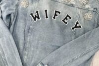 a blue grey ripped denim bridal jacket with WIFEY letters and vintage brooches on the shoulders and back is a very refined idea