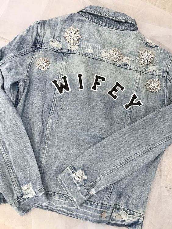 a blue grey ripped denim bridal jacket with WIFEY letters and vintage brooches on the shoulders and back is a very refined idea