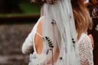 a bold dried and fresh flower crown with purple blooms and herbs and with a floral embroidery veil for a boho bridal look