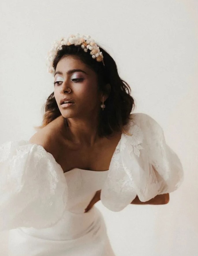 a catchy and stylish lace wedding dress with puff sleevs and a delicate neutral dried flower tiara as a perfect fit for the look