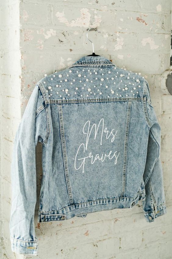a classic bleach blue denim jacket with a bit of calligraphy and pearls on the back is a cool and romantic solution