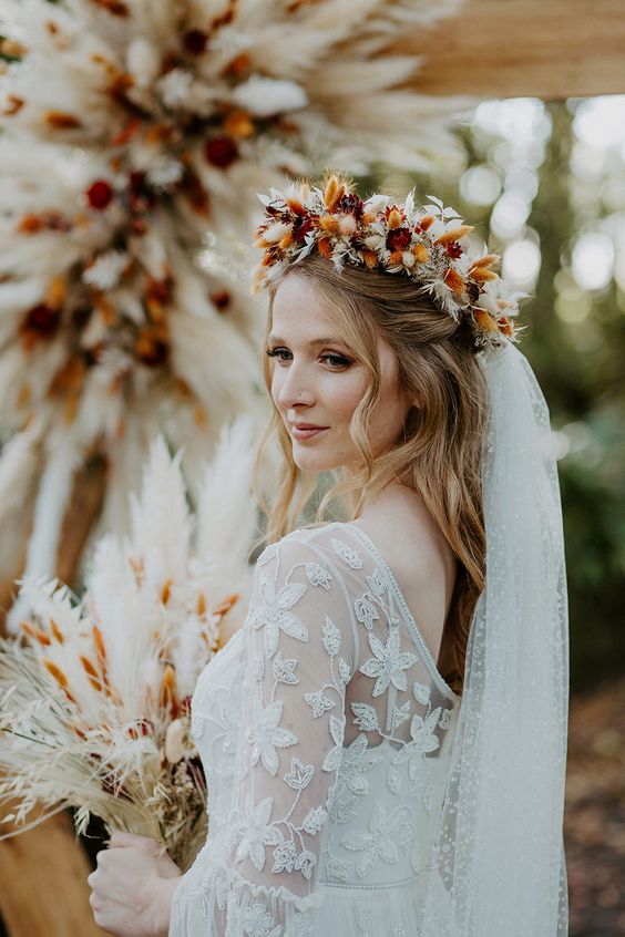 a cool rust-colored and neutral dried flower crown, a matching bouquet and wedding arch for a fall boho wedding