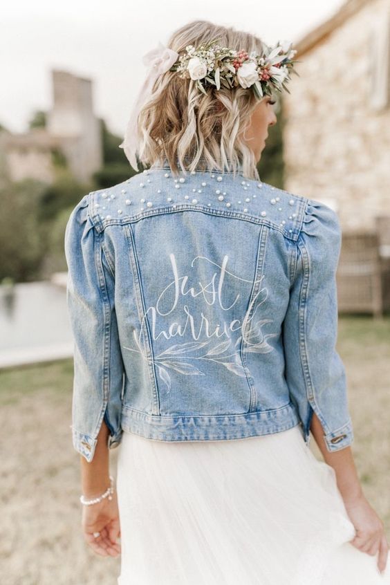 a delicate blue denim cropped bridal jacket with short sleeves, a bit of calligraphy and pearls over the shoulders is chic