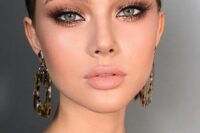 a gorgeous wedding makeup with a glossy nude lip, glitter brown smokey eyes, lash extensions, a touch of blush