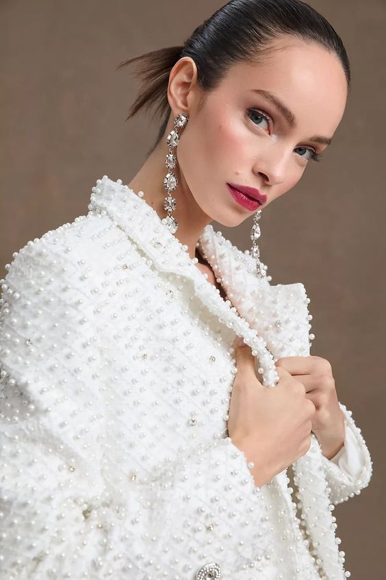 a jaw-dropping fully pearl embellished white bridal jacket and statement earrings will make your wedding look unforgettable