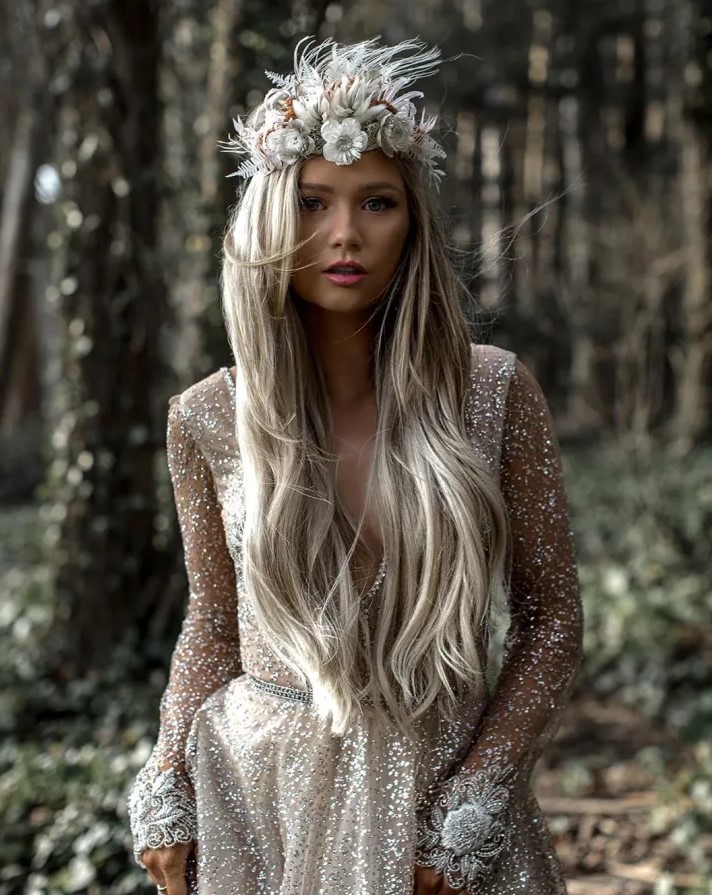 a jaw-dropping glam bridal look with a sparkling wedding dress with an embellished sash and a white dried flower crown
