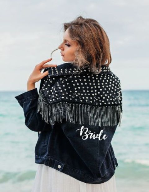 a navy denim oversized bridal jacket with crystals all over the shoulders and collar, with long crystal fringe and calligraphy