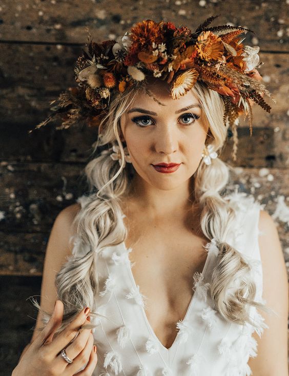 a super lush and bold dried flower crown done in rust, orange and neutrals, with herbs and leaves is a catchy idea for a fall bride