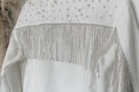 a white denim bridal jacket with pearls on the back and shoulders and long crystal fringe is a chic glam cover up