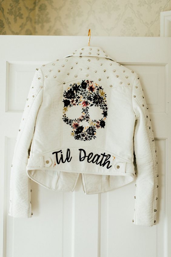 a white leather bridal jacket with crystals on the shoulders and sleeves, a painted floral skull is a bold solution
