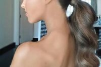 03 a beautiful and elegant wavy low ponytail with a sleek and shiny top is a stylsih idea for a glam bride