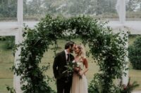 04 a fabulous round wedding arch all covered with textural greenery and foliage is a lovely idea for a non-floral wedding