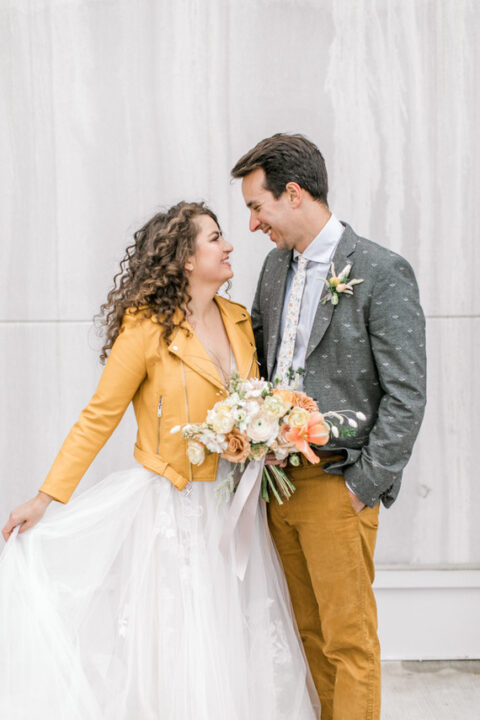 a bride wearing a marigold leather jacket and a groom rocking matching pants plus printed clothes look very bold and cool