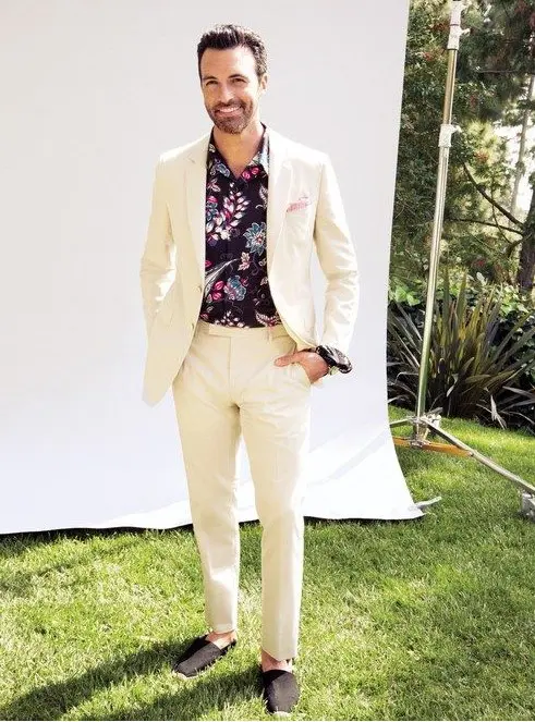 a creamy suit, black espadrilles and a moody floral shirt, which is great for a tropical wedding