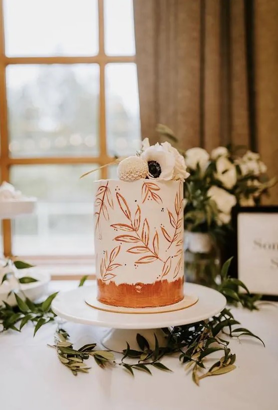 a delicate fall wedding cake with hand painted rust leaves and rust brushstrokes, with white blooms on top is amazing for a modern wedding