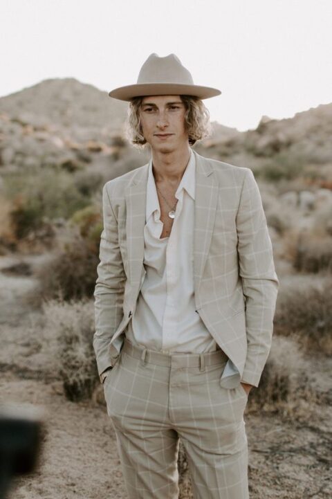 a dove grey windowpane pantsuit, a white shirt and a creamy hat are a great combo for a boho wedding