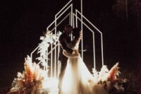 07 geometric LED arches and lights on the ground plus florals and pampas grass for a gorgeous night wedding ceremony