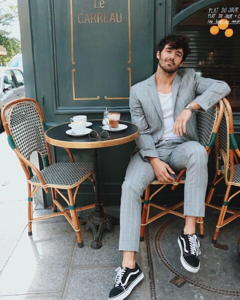 a grey linen thin stripe suit, a white t-shirt and black sneakers for a relaxed and informal summer wedding